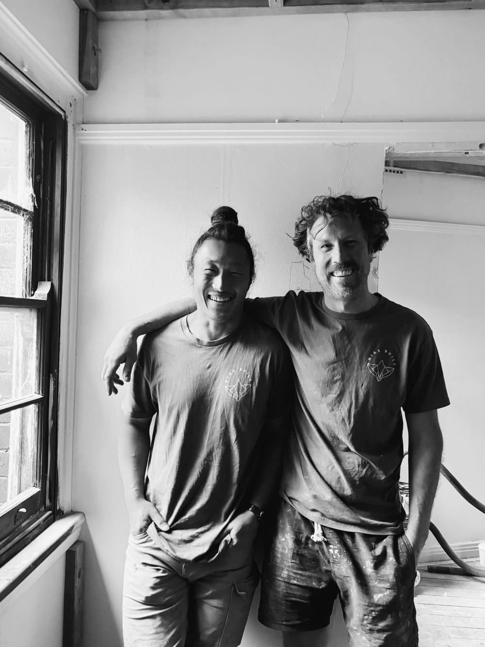 Two friends smiling inside the building during its restoration