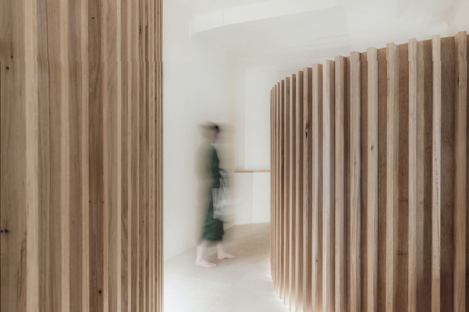 A guest walking past the curved timber walls